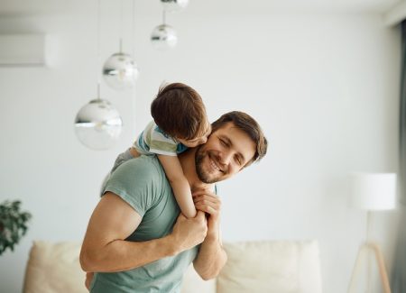 Ein junger Vater hat seinen Sohn auf dem Rücken