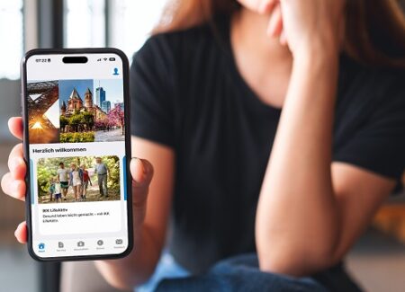 Eine Frau hält ein Smartphone in der Hand, auf dem der Bildschirm der "IKK Südwest App" angezeigt wird.