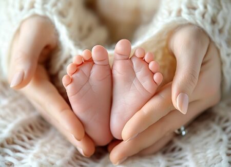 Eine Mutter hält die Füße ihres neugeborenen Babys