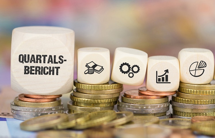 Würfel mit der Aufschrift Quartalsbericht sowie weiteren Symbolen, die auf Münzen stehen