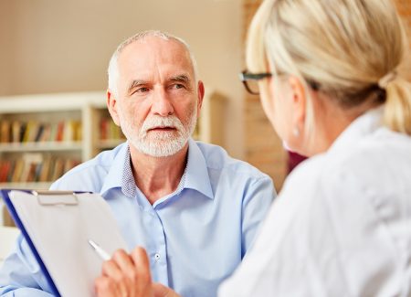 Ein älterer Herr lässt sich vom Gesundheitspersonal beraten