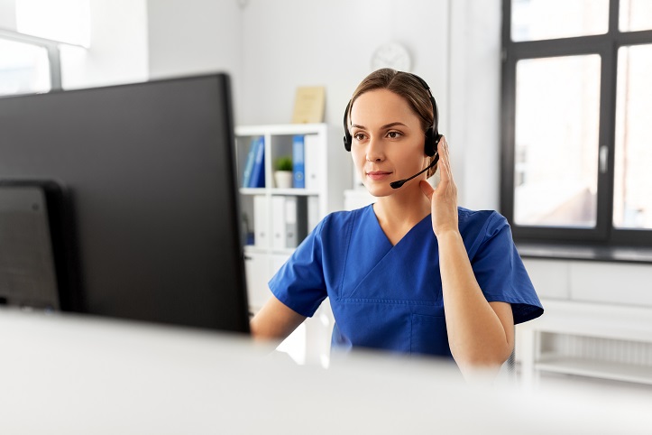 Medizinisches Fachpersonal mit Headset vor einem Bildschirm