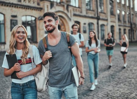 Eine Gruppe von Studenten läuft vor einem Gebäude