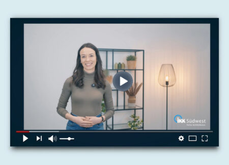 Eine lächelnde Frau steht vor einem Regal und einer Lampe und erscheint im pausierten Videoplayer-Fenster. Unten rechts ist das Logo der IKK Südwest zu sehen.