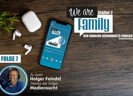 Auf einer Holzfläche steht ein Smartphone mit dem Cover des We-are-family-Podcasts