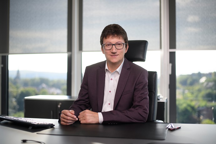 IKK-Südwest-Vorstand Prof. Dr. Jörg Loth sitzt an einem Bürotisch.