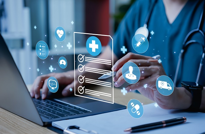 Eine medizinische Fachkraft mit einen Laptop. Sie hält einen digitalen Stift mit schwebenden medizinischen Symbolen.